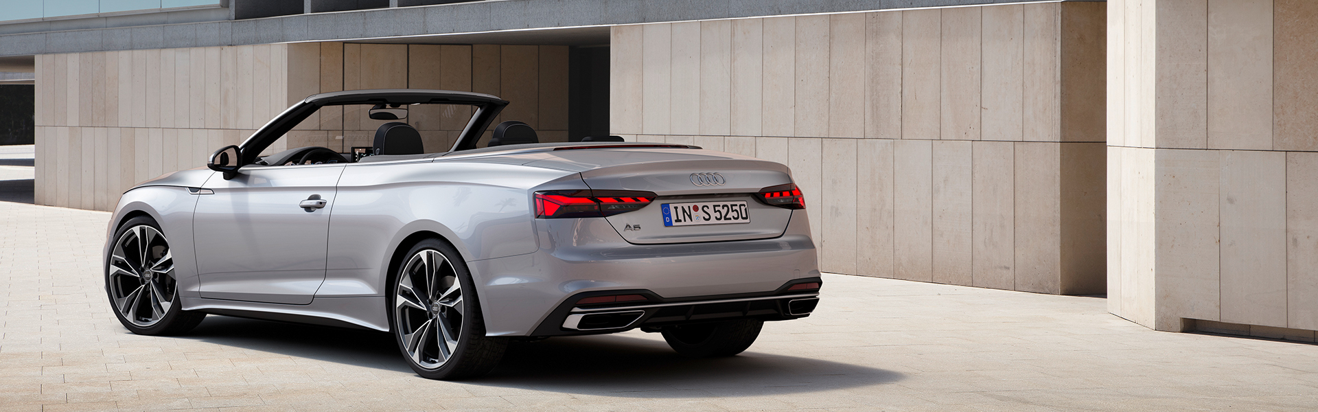 Ein silberner Audi A5 Cabriolet in der Dreiviertelansicht von Hinten