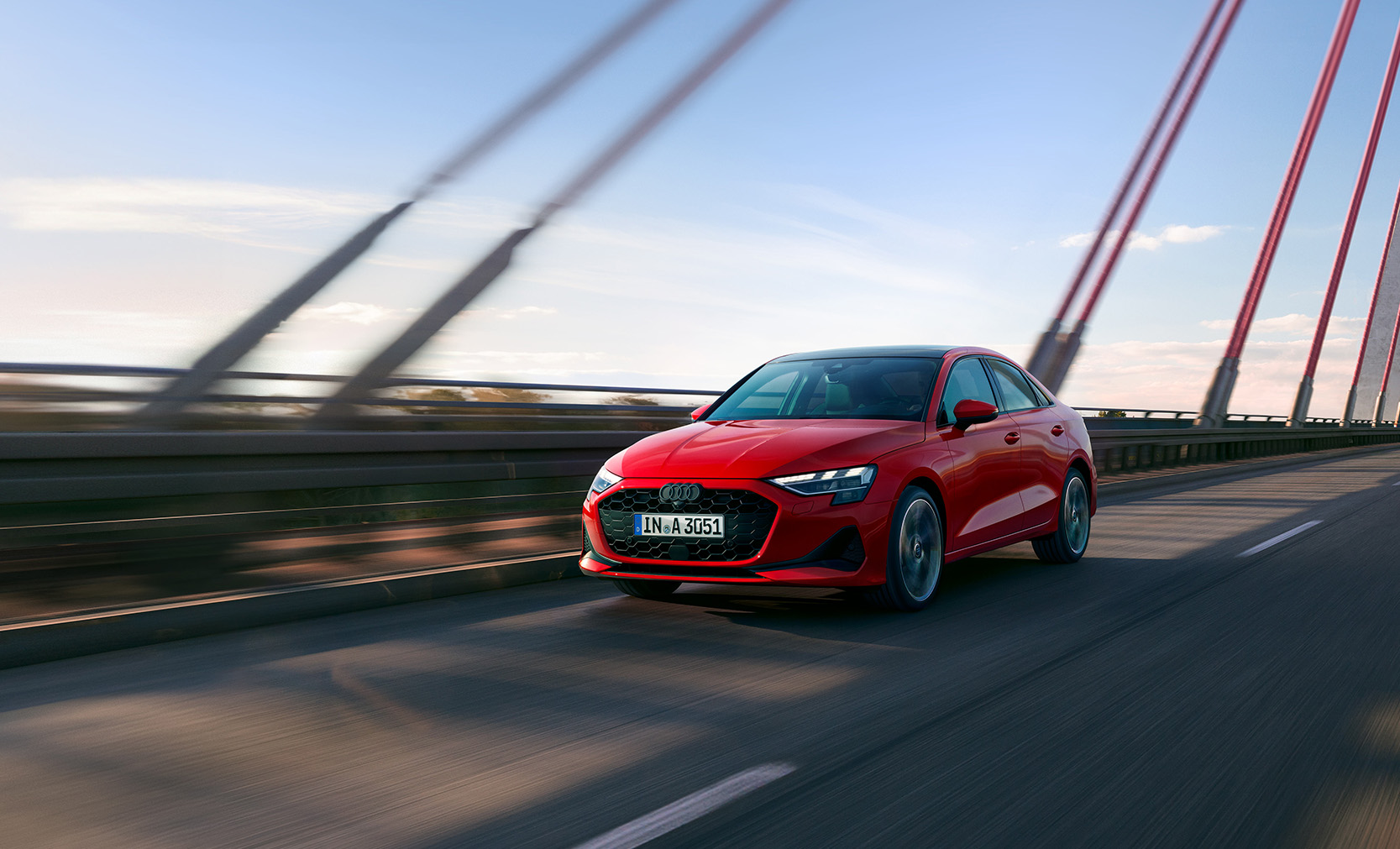 Eine rote Audi A3 Limousine f&auml;hrt &uuml;ber eine Br&uuml;cke