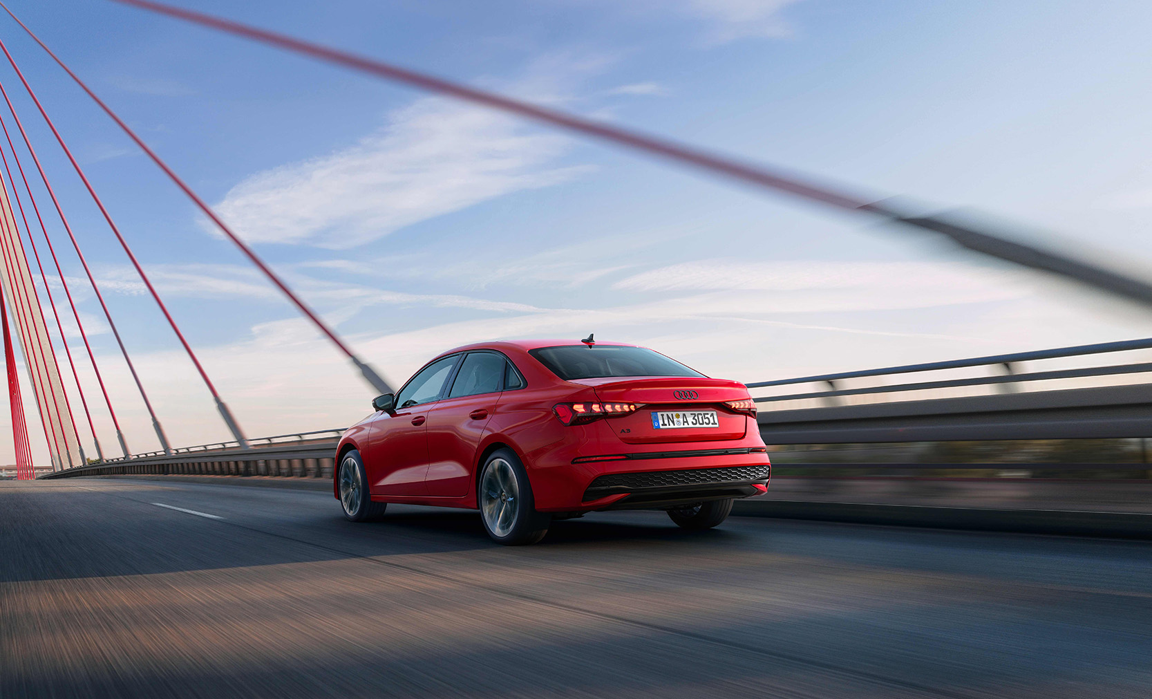 Eine rote Audi A3 Limousine &uuml;ber eine Br&uuml;cke fahrend