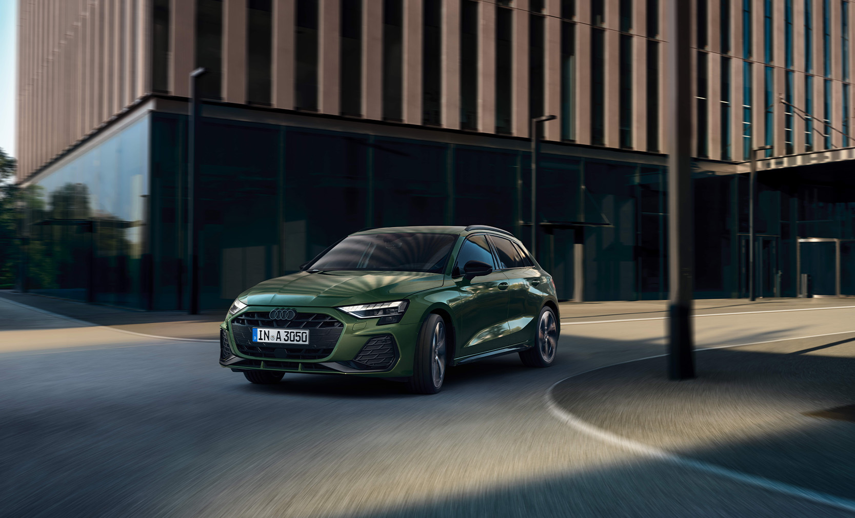 Gr&uuml;ner Audi A3 Sportback in Frontansicht auf der Stra&szlig;e.