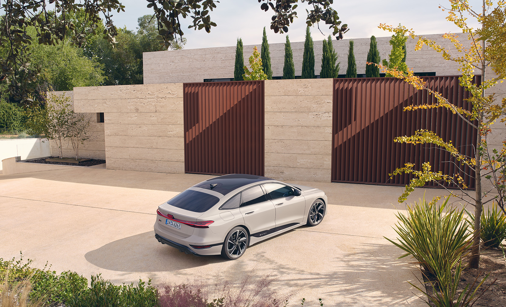 Eine cremefarbener A6 Sportback e-tron vor einer Auffahrt