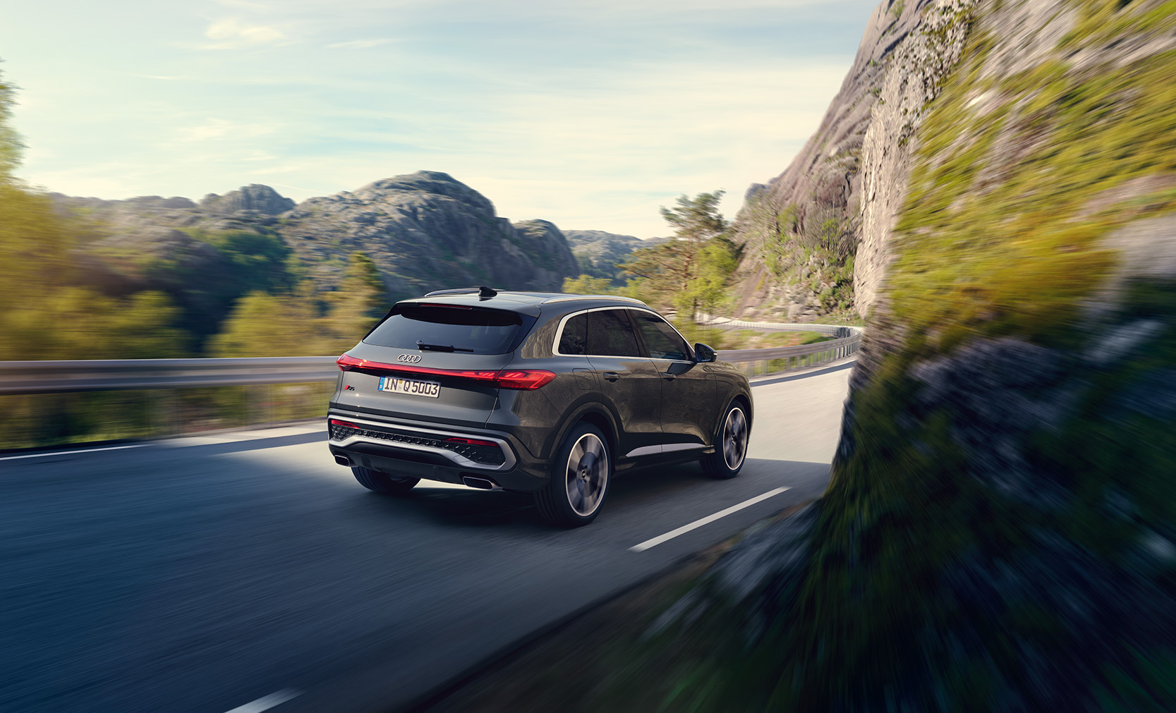 Der neue Audi SQ5 SUV TFSI auf einer Landstra&szlig;e in der Dreiviertelansicht von hinten 