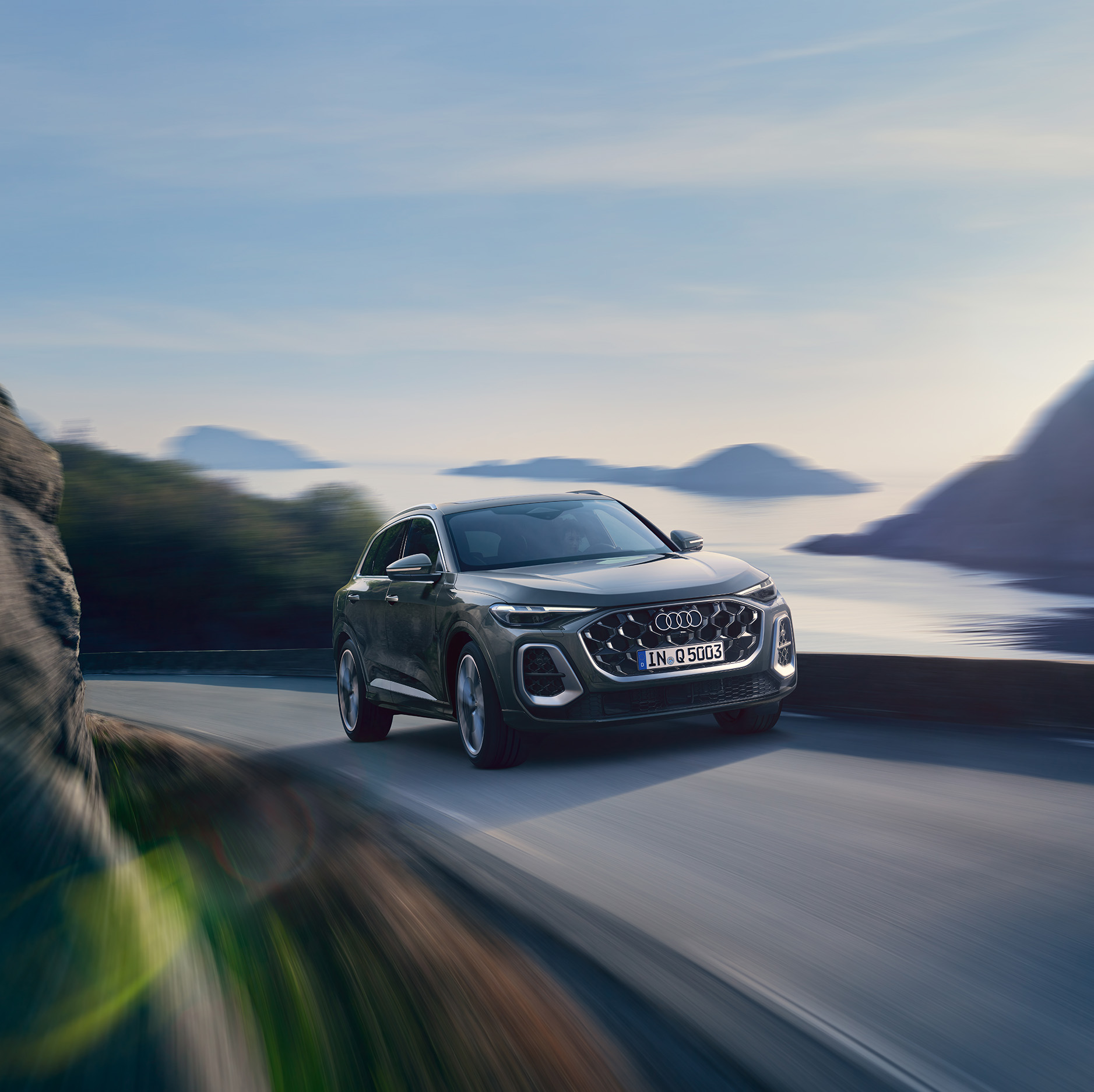 Der graue Audi Q5 SUV in Frontansicht, der eine Bergstra&szlig;e hoch F&auml;hrt