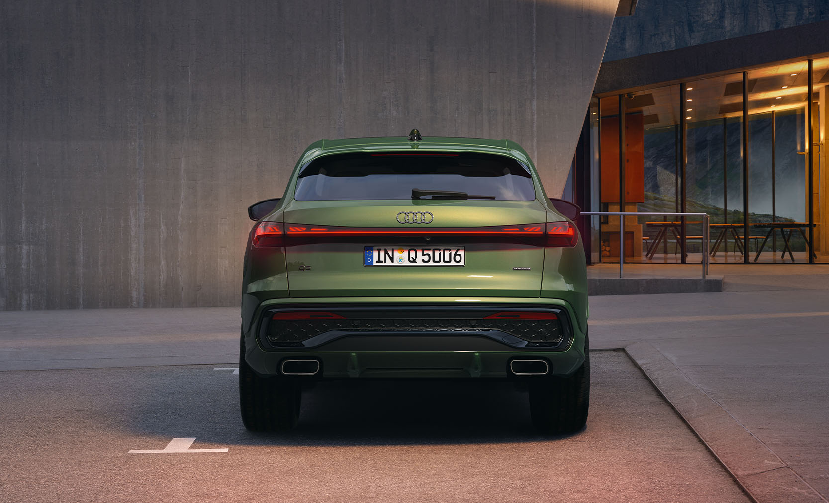 Ein gr&uuml;ner Audi Q5 Sportback in der Heckansicht vor einem Geb&auml;ude