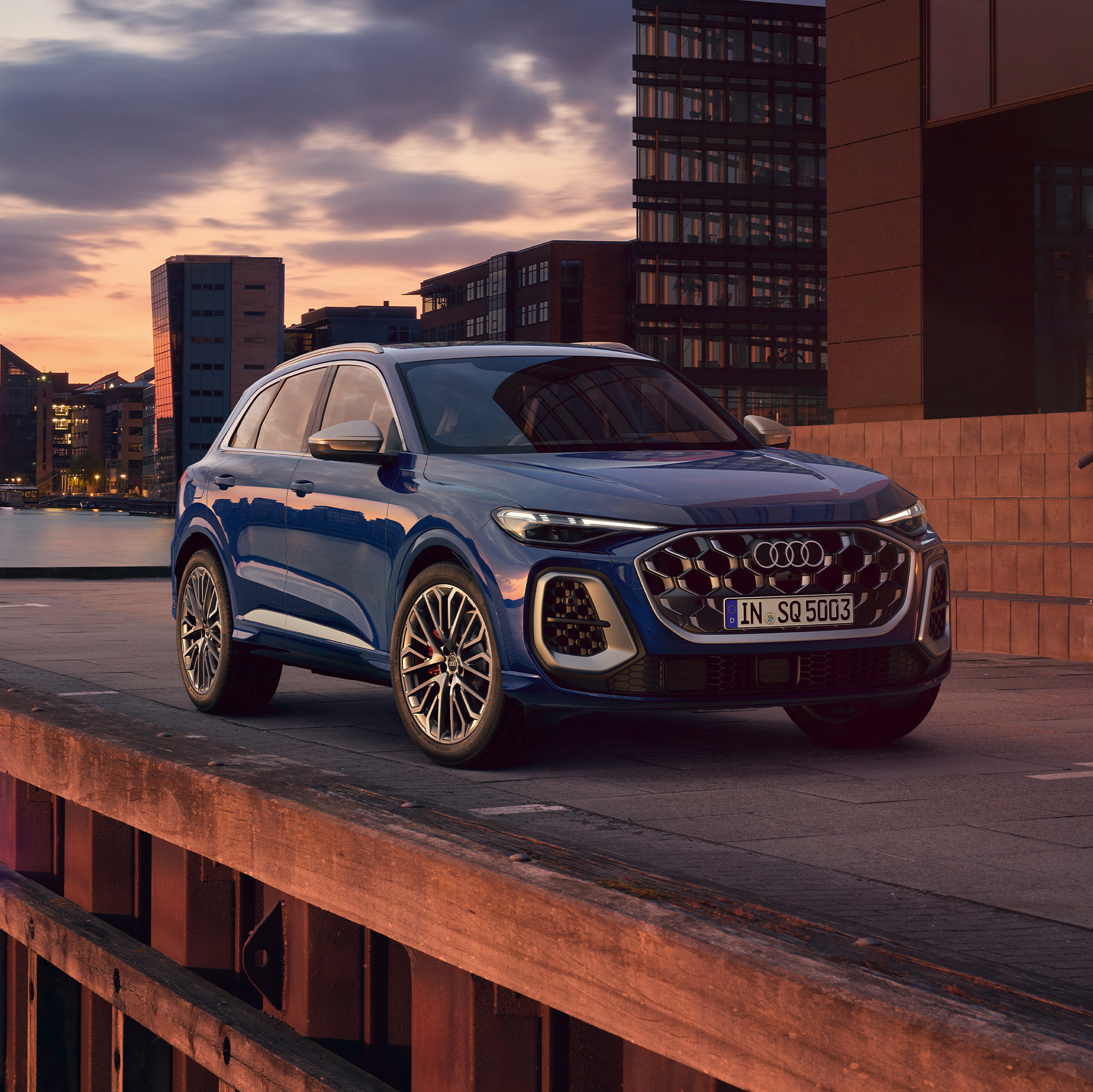 Der Audi SQ5 SUV TFSI in der Dreiviertel Ansicht an einem Hafengel&auml;nder bei Sonnenuntergang