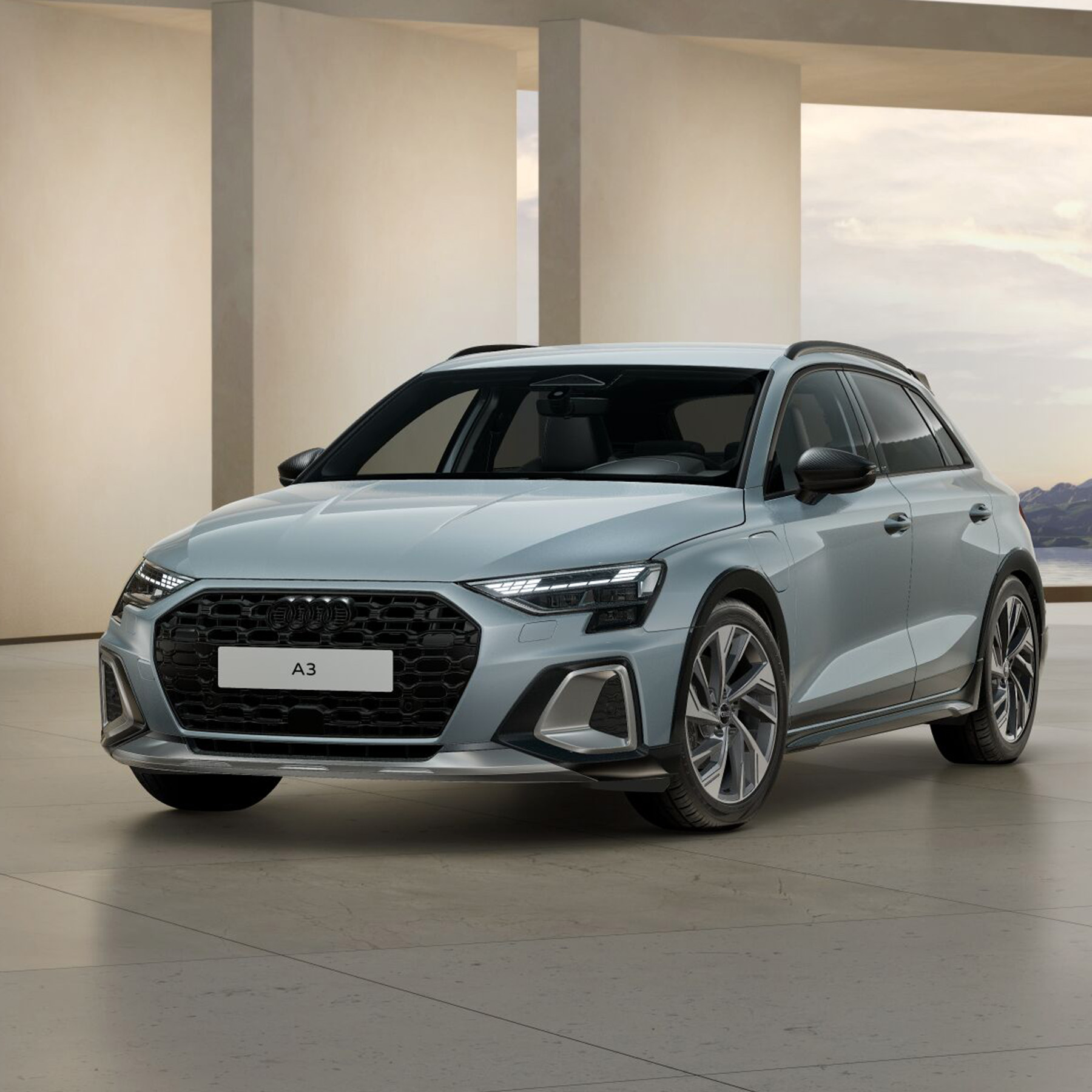 Ein grauer Audi A3 allstreet TFSI e in Front-Seitenansicht vor einem Geb&auml;ude