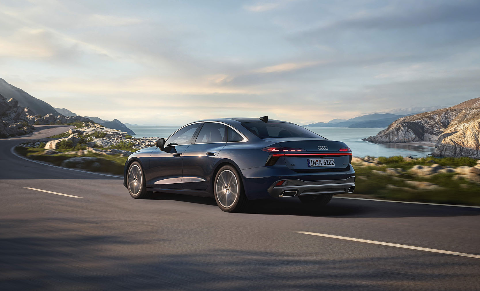 Ein brauner Audi A6 in der seitlichen, von hinten abgebildeten Dreiviertelansicht auf einer Stra&szlig;e