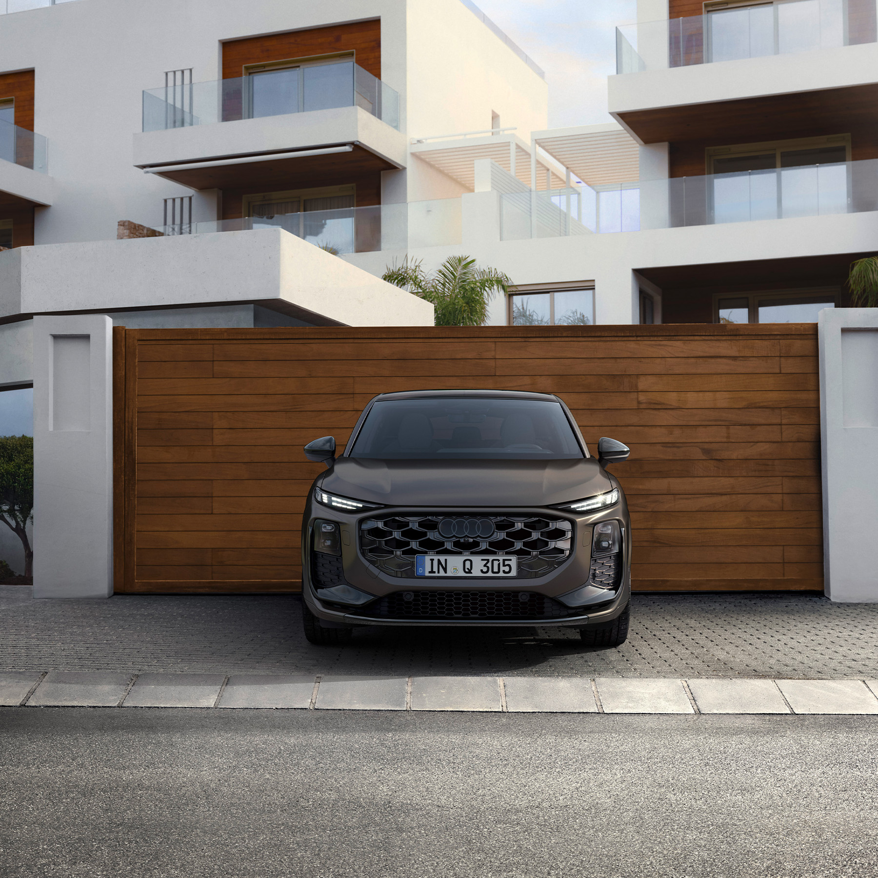 Audi Q3 Sportback, grau, Frontansicht  vor einem Mehrfamilienhaus