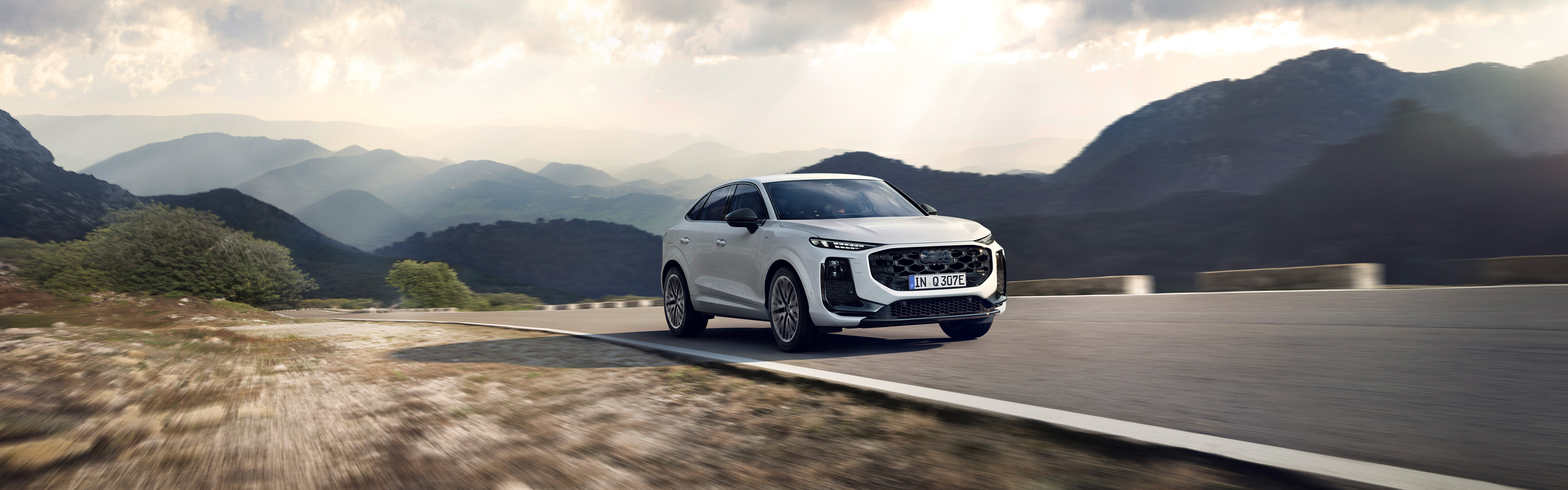 Audi Q3 Sportback, wei&szlig;, Seitenansicht von vorn vor Bergkulisse