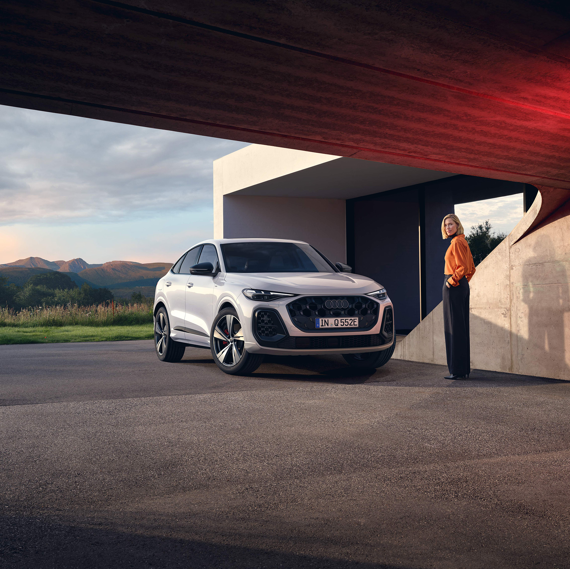 Ein wei&szlig;er Audi Q5 Sportback e-hybrid in der Dreiviertelansicht vor einem Geb&auml;ude