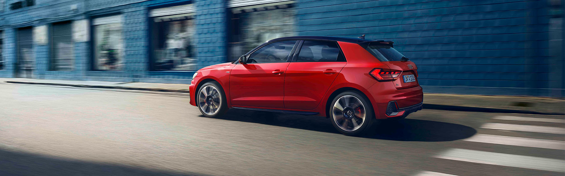 Roter Audi A1 Sportback in Heckansicht, f&auml;hrt auf der Stra&szlig;e
