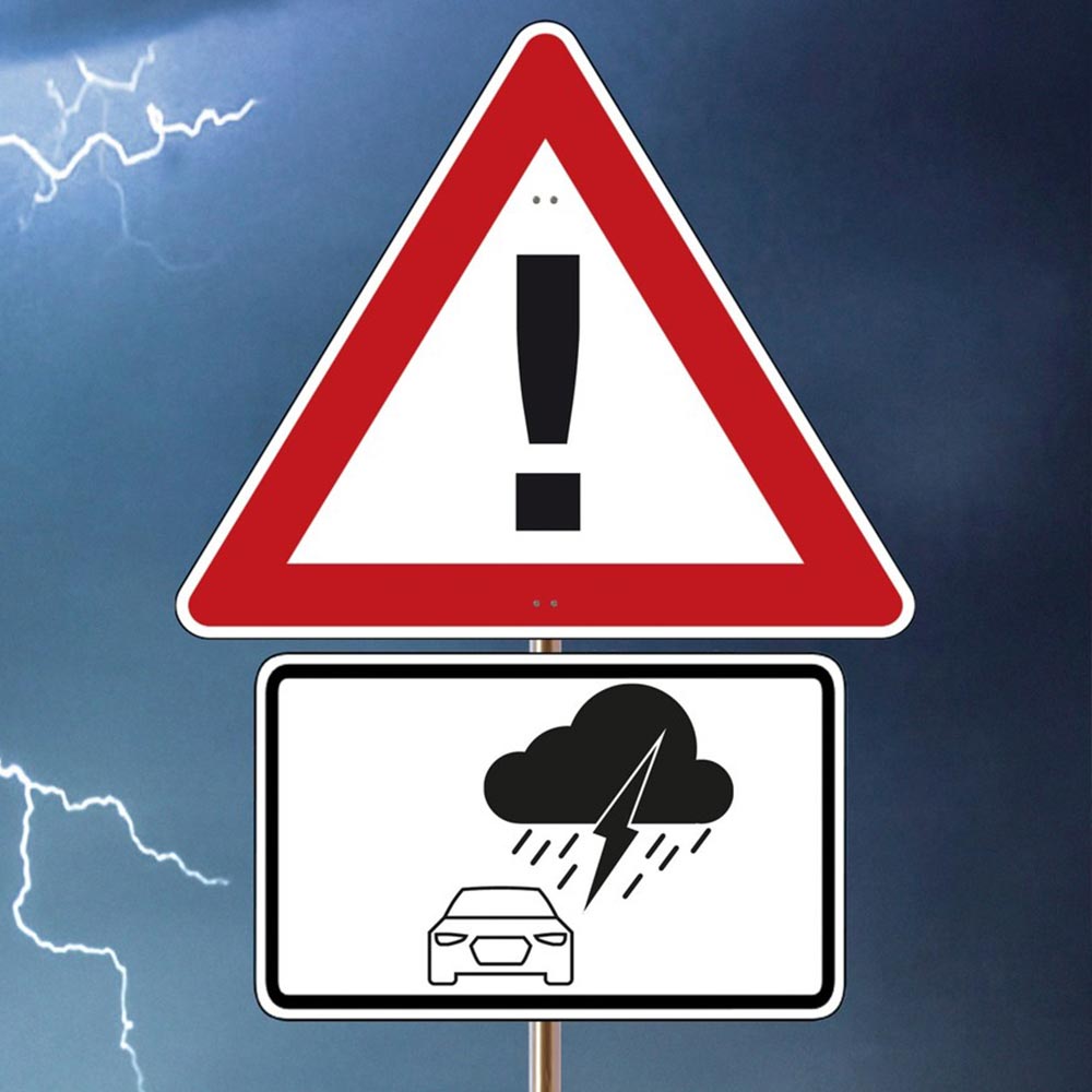 Gewitter mit Warnschild im Vordergrund