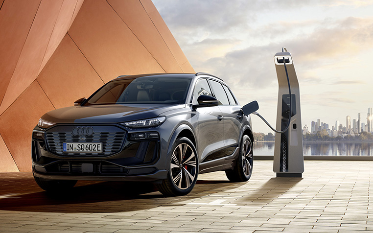 Audi SQ6 e-tron steht neben einer Lades&auml;ule.