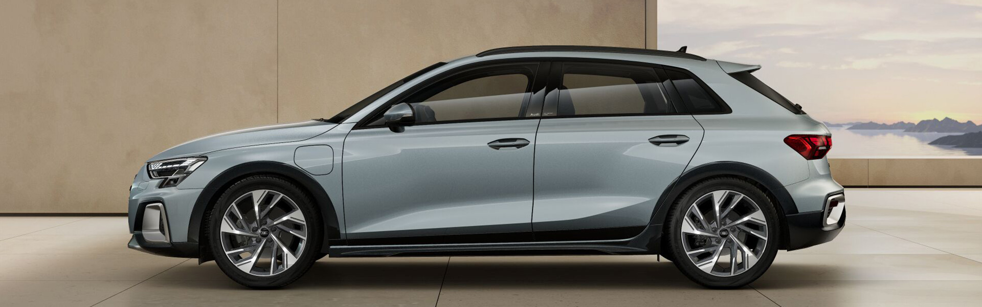 Ein grauer Audi A3 allstreet TFSI e seitlich vor einem Geb&auml;ude