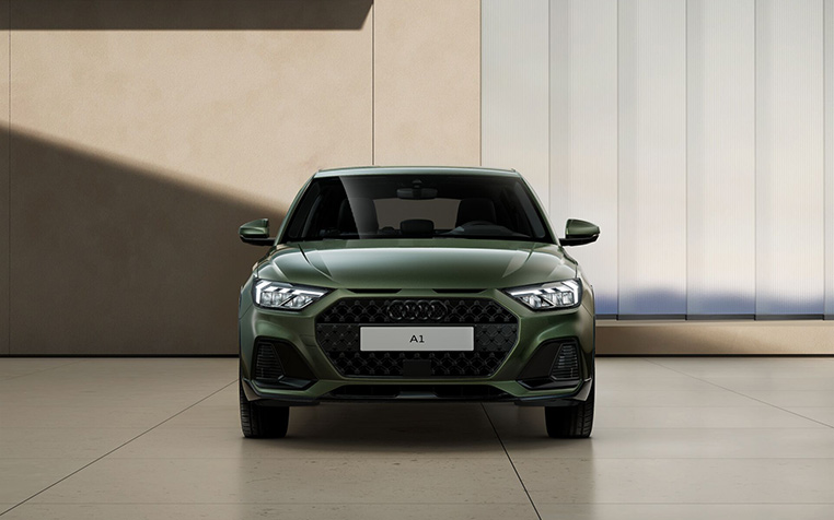 Audi A1 allstreet in Distriktgr&uuml;n Metallic Front in beigem Geb&auml;ude