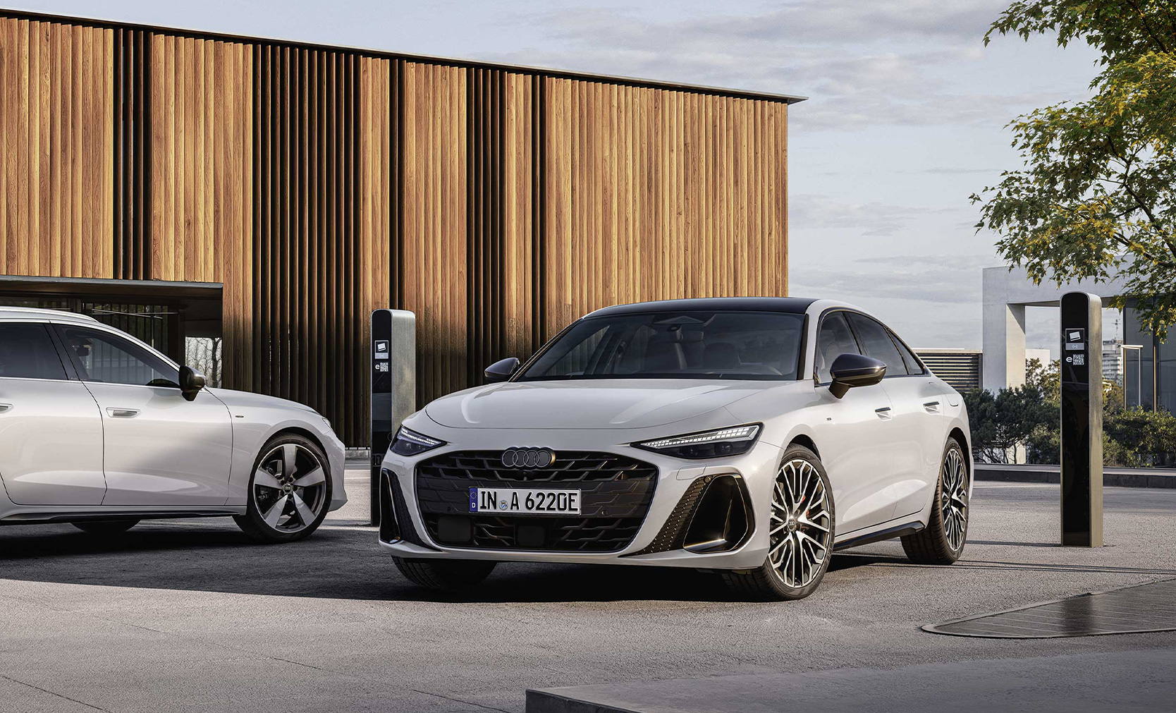 Zwei Audi A6 Avant e hybrid stehen an der Lades&auml;ule. 
