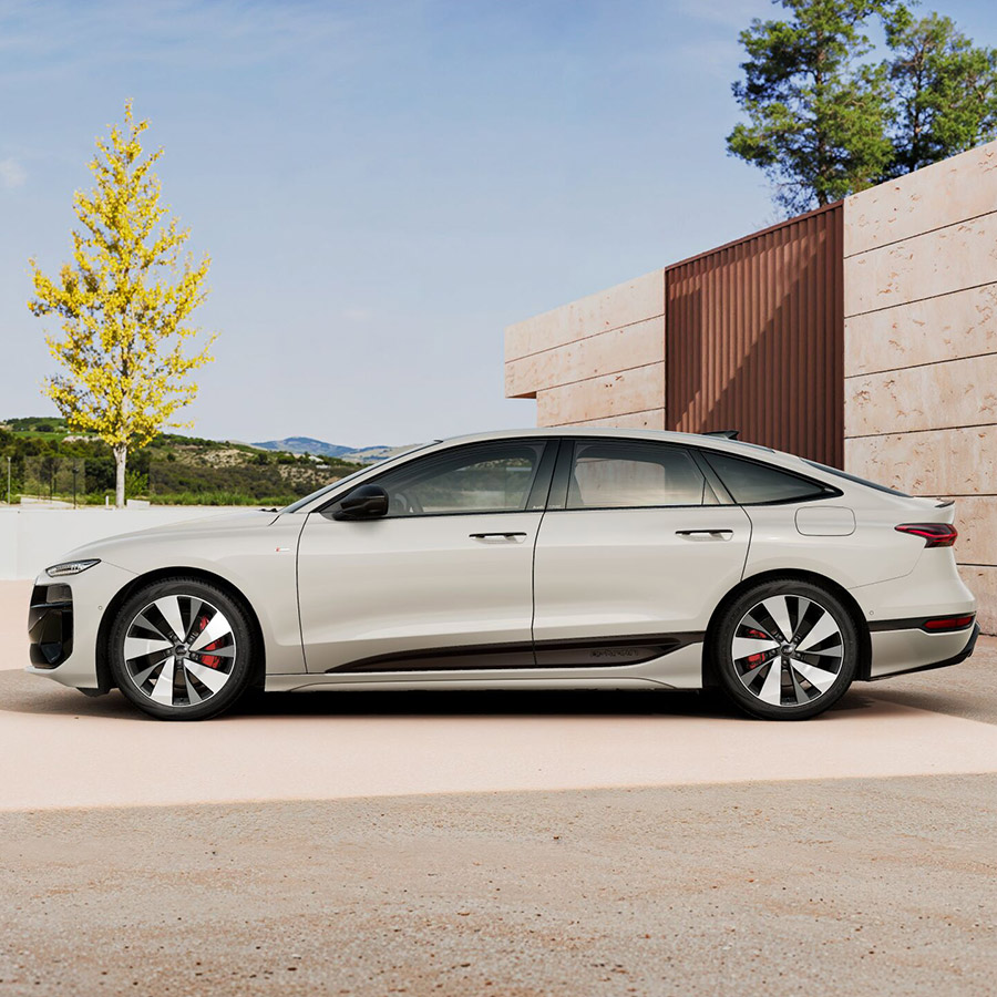 Ein Audi A6 Sportback e-tron in Siambeige Metallic vor einem Wohnhaus