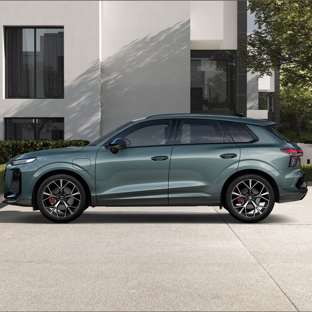 Ein Audi Q3 SUV e-hybrid in Salbeigr&uuml;n Metallic in der Seitenansicht