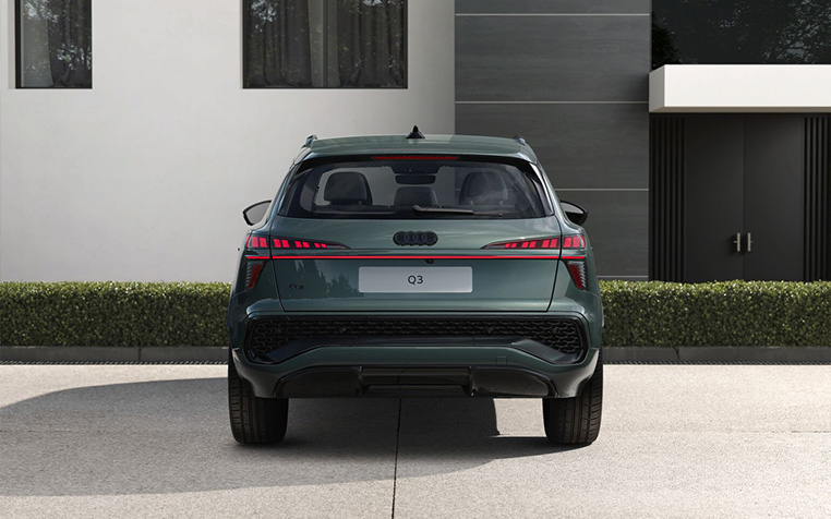 Ein Audi Q3 SUV e-hybrid in Salbeigr&uuml;n Metallic in der Heckansicht