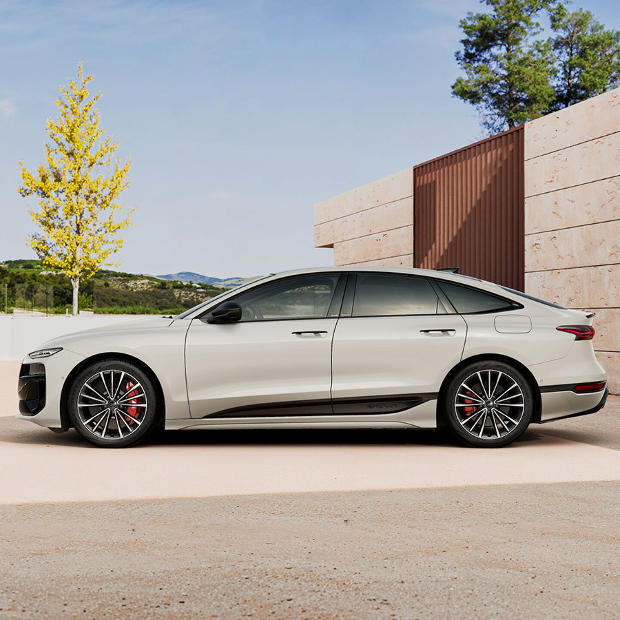 Ein Audi S6 Sportback e-tron in Siambeige Metallic seitlich in Hofeinfahrt