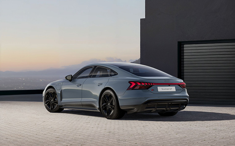 Graublauer Audi S e-tron GT seitliche Heckansicht vor schwarzem Geb&auml;ude